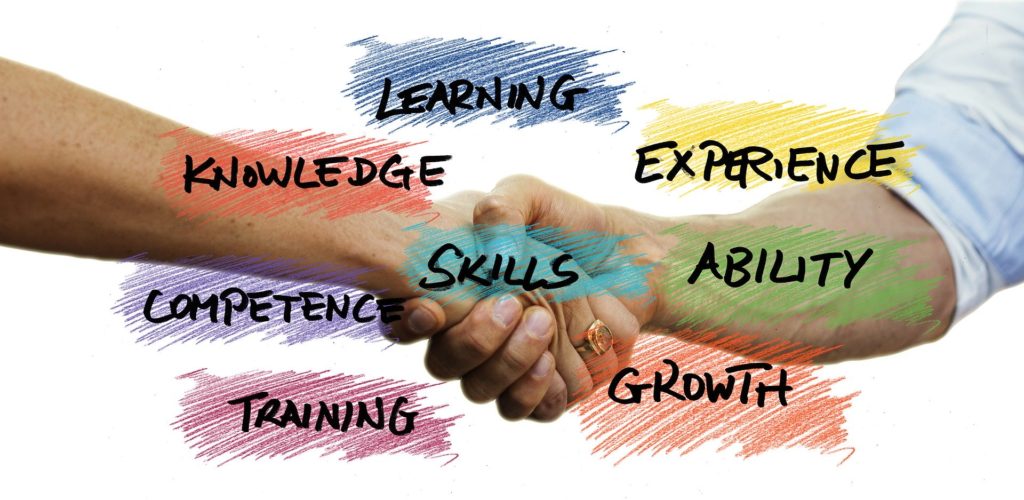 Hands Shaking behind the words learning, knowledge, experience, skills, competence, ability, training, and growth