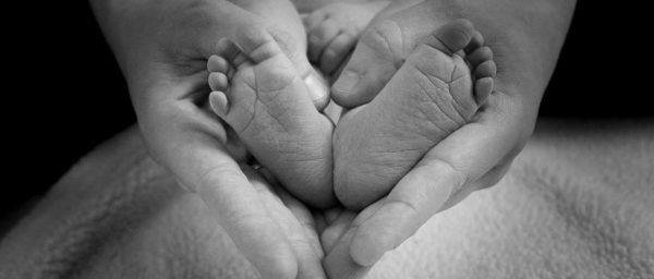 Newborn feet in the hands of a parent