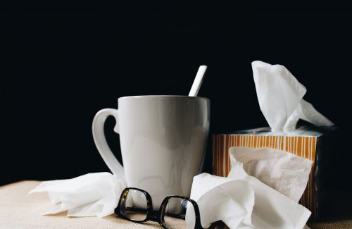 cup of tea next to a box of tissues and glasses